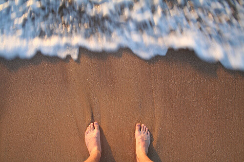 fötter på sandstrand