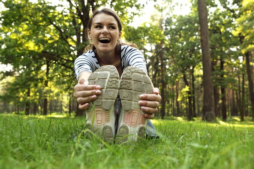 glad person som sitter på marken och stretchar