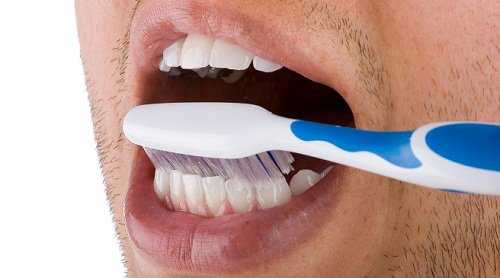 Man som borstar tänderna