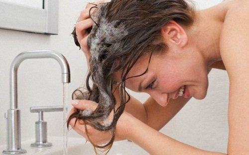 Kvinna schamponerar håret