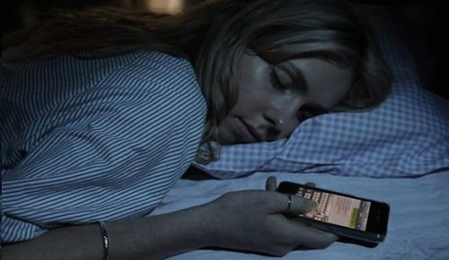 Sover med mobiltelefon