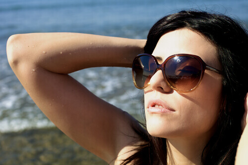 person som solar vid stranden