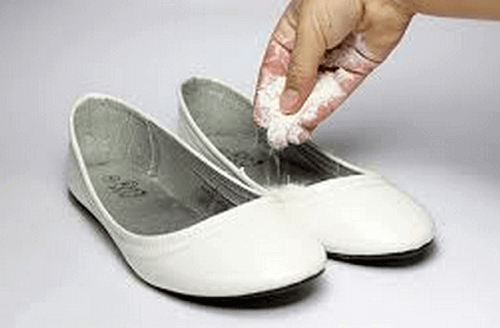 person som lägger bikarbonat i skor för att motverka lukt