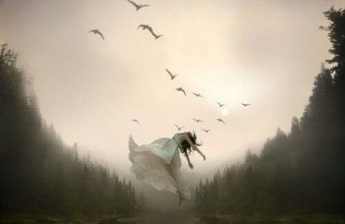 kvinna på äng med fåglar som flyger
