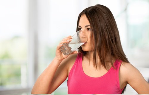 kvinna som dricker ett glas vatten