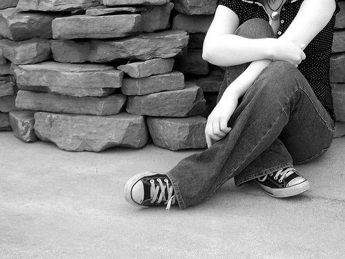 person som sitter vi stenmur