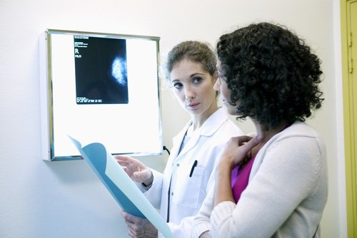 läkare diskuterar bröstcancertumörer med patient
