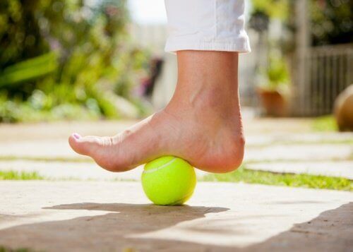 En tennisboll för att lindra smärta från plantarfasciit