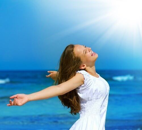 kvinna-badar-i-solljus-på-strand