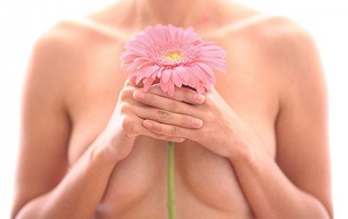 kvinna med blomma framför bröstet