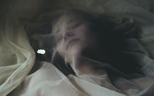 kvinna med lakan över huvudet