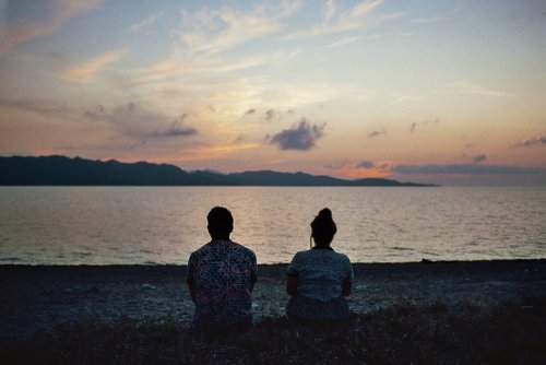 par sittandes vid en sjö