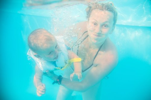 Kvinna i pool med bebis