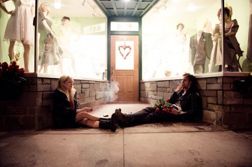 par som sitter utanför affär och röker