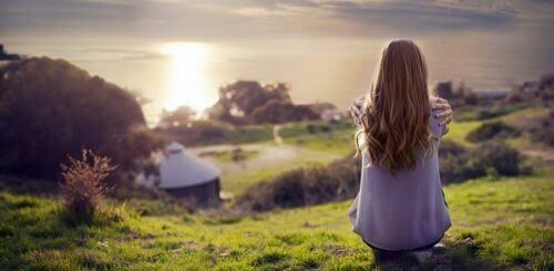 kvinna på kulle vid solnedgång