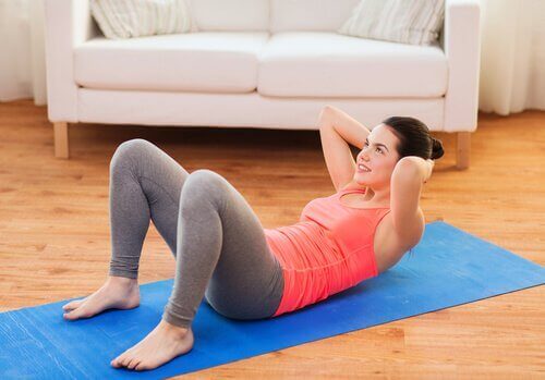 kvinna gör situps på matta