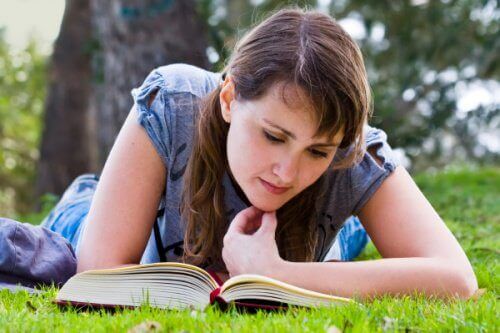 Kvinna läser i gräset