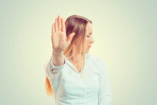 Kvinna håller upp handen framför sig