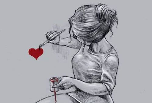 Flicka målar ett hjärta på väggen