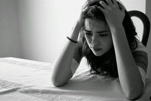 Förtvivlad kvinna vid bord