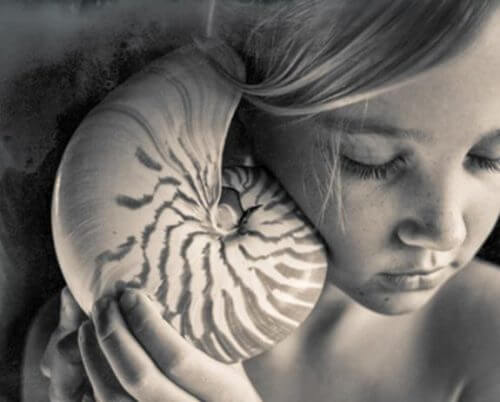 Flicka med snäckskal mot örat