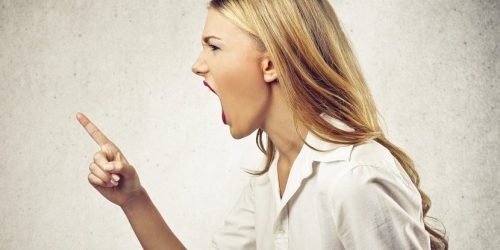 Kvinna skriker med fingret i vädret