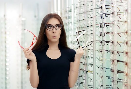 Kvinna med beslutsångest över vilka glasögon hon ska köpa