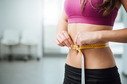 Kvinna som mäter magen