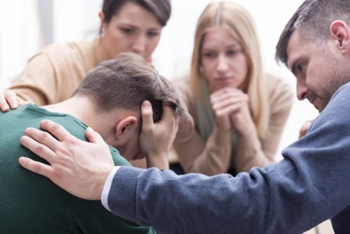 Personer tröstar i grupp