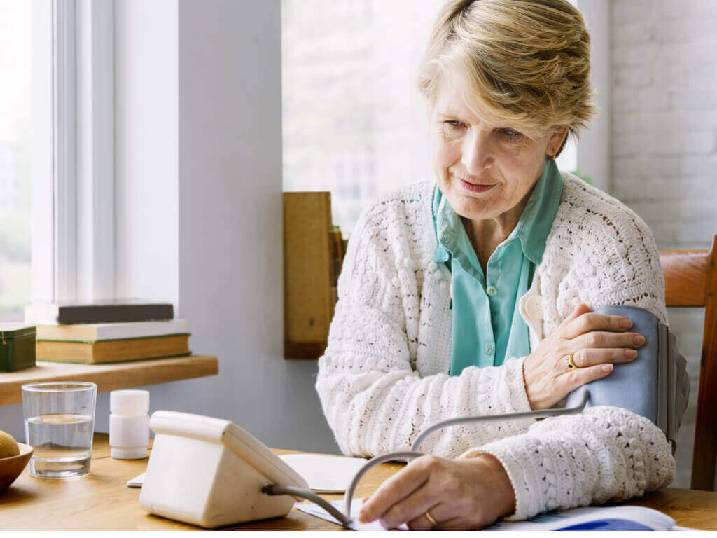 Kvinna som mäter blodtrycket