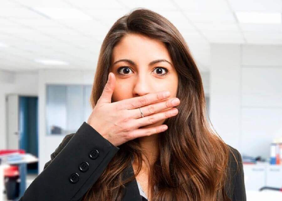 Kvinna som håller handen för munnen