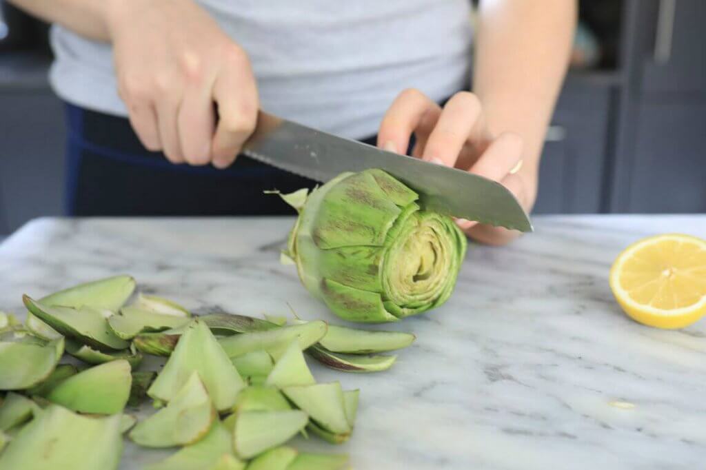 Person som skivar kronärtskocka