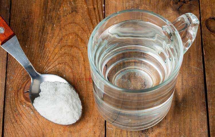 bordssalt i sked och glas med vatten