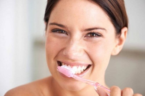 Kvinna borstar tänderna för att motverka karies