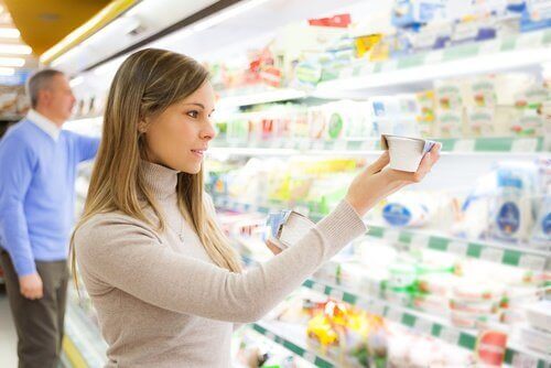 kvinna kollar ingredienserna på yoghurt