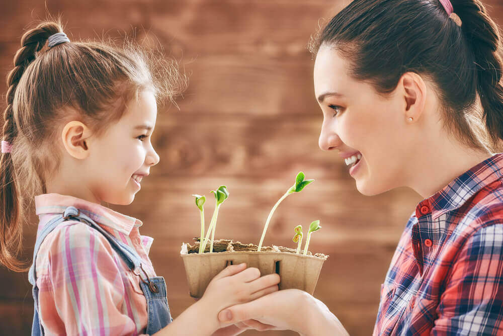 Planterar blommor med dotter