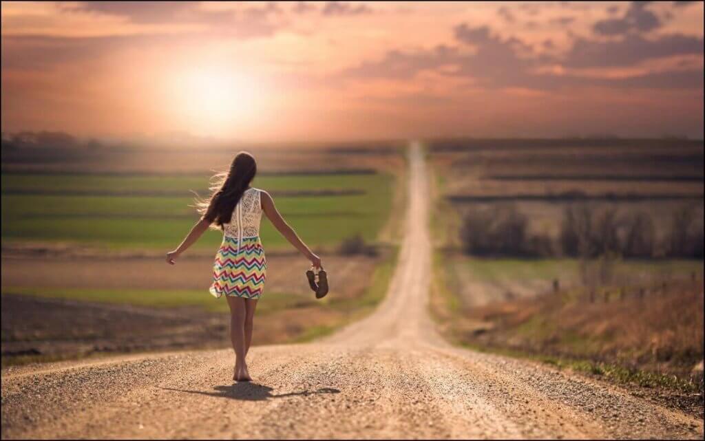 Kvinna som går på landsväg.
