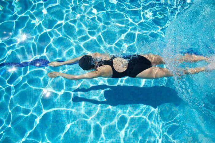Kvinna som använder tekniker för att simma i en pool.