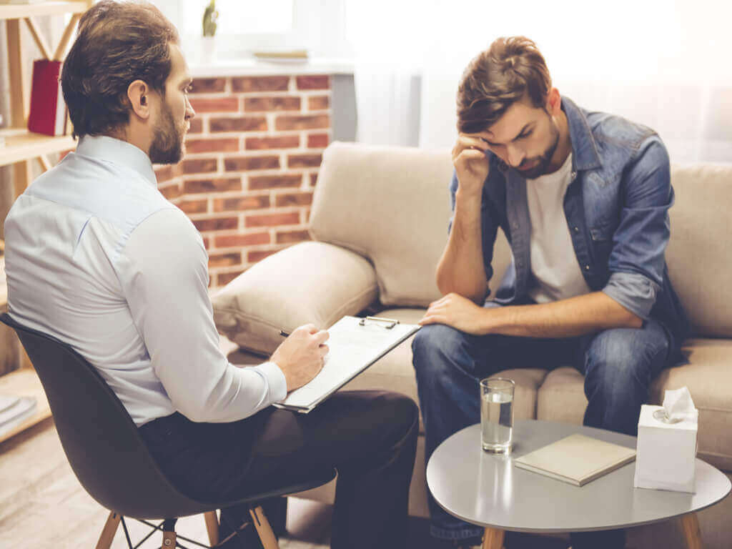 Man som sitter på soffan.