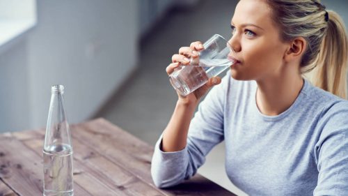 Kvinna som dricker vatten.