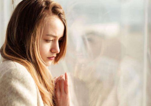 Kvinna som står vid fönstret.