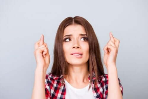 Kvinna som håller tummarna.