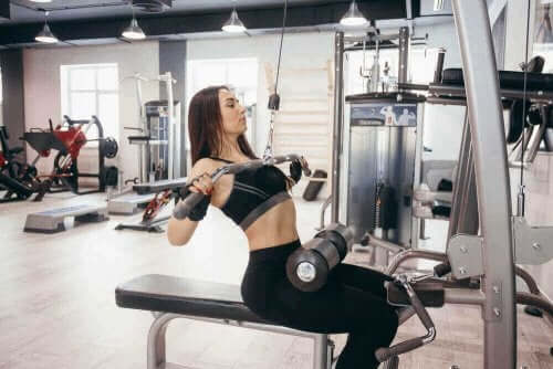 Kvinna styrketränar på gym