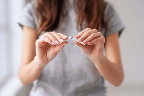 Kvinna bryter av en cigarett.