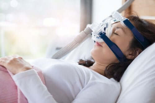 En kvinna med cpap-maskin som behandling mot snarkningar.