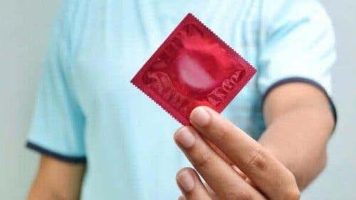 Mycoplasma genitalium: man håller upp kondom