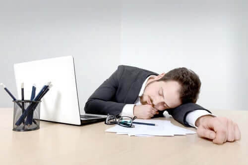 en man som sover vid sitt skrivbord