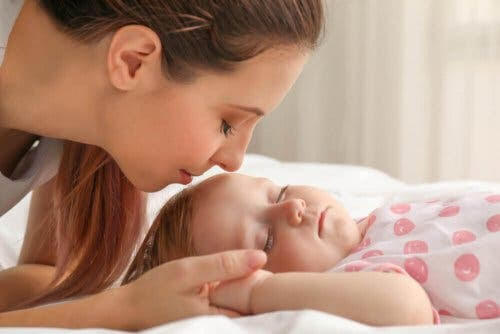 Skallasymmetri: mamma kysser sovande baby