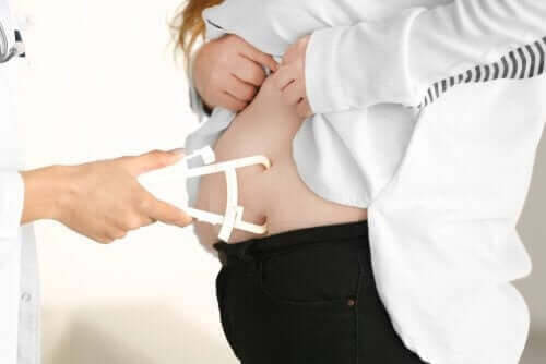 läkare undersöker buken på kvinna som ett steg i att förhindra fetma