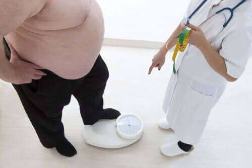 överviktig person väger sig hos läkare